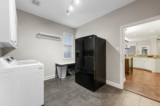 laundry room featuring visible vents, cabinet space, washer and dryer, and baseboards