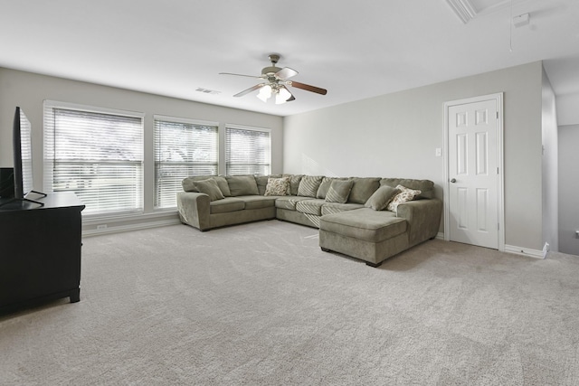 living area with visible vents, baseboards, attic access, carpet flooring, and a ceiling fan