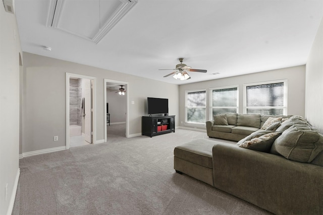 carpeted living area featuring visible vents, attic access, baseboards, and a ceiling fan