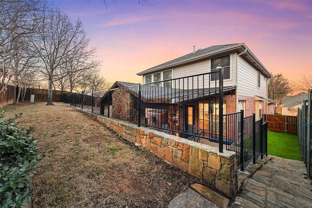 back of house with a patio, a fenced backyard, brick siding, and a lawn