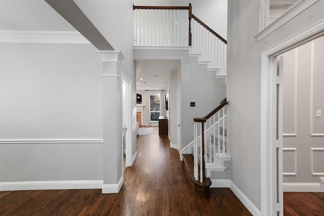 foyer with stairway, baseboards, decorative columns, and hardwood / wood-style flooring