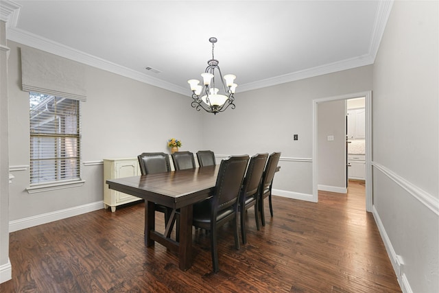 dining area with a chandelier, baseboards, wood finished floors, and crown molding