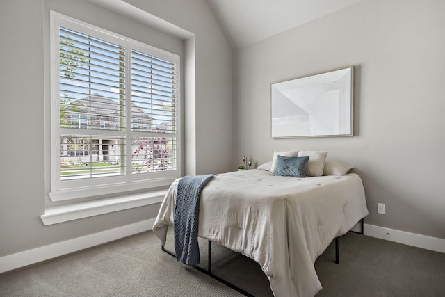carpeted bedroom with baseboards and vaulted ceiling