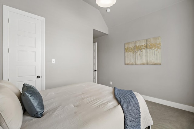 carpeted bedroom with baseboards and vaulted ceiling
