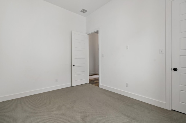 carpeted spare room featuring baseboards and visible vents