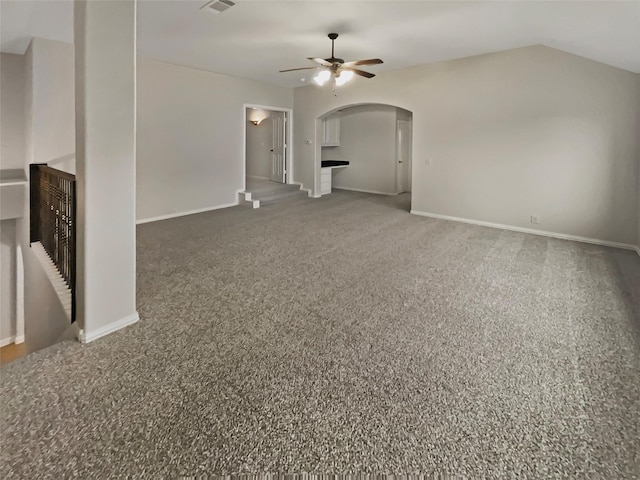 unfurnished living room featuring baseboards, carpet floors, lofted ceiling, arched walkways, and ceiling fan