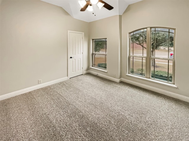 spare room with lofted ceiling, light colored carpet, baseboards, and ceiling fan