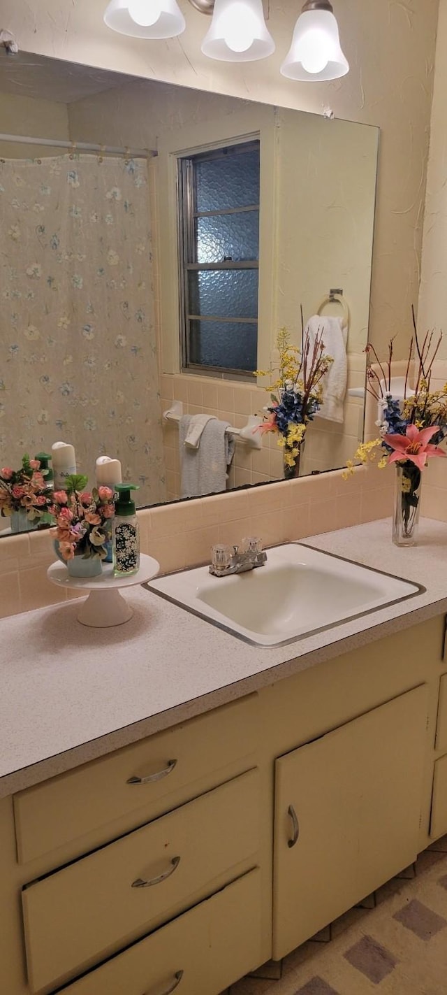 bathroom with curtained shower, tasteful backsplash, and vanity