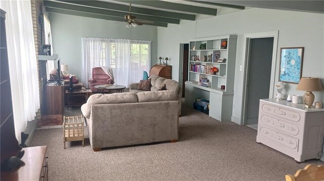 carpeted living area featuring beamed ceiling and ceiling fan