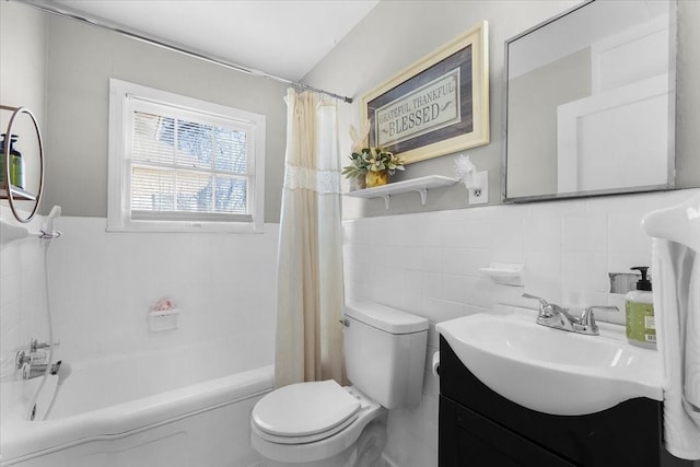bathroom with wainscoting, toilet, vanity, and tile walls