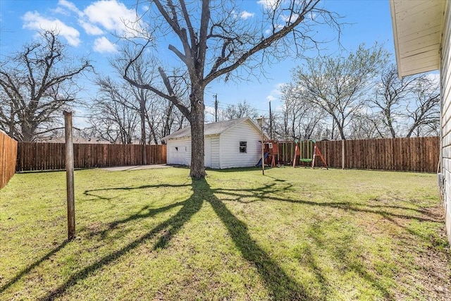 view of yard with an outbuilding, a garage, and a fenced backyard