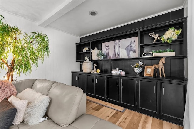 living area with beamed ceiling and light wood-style floors