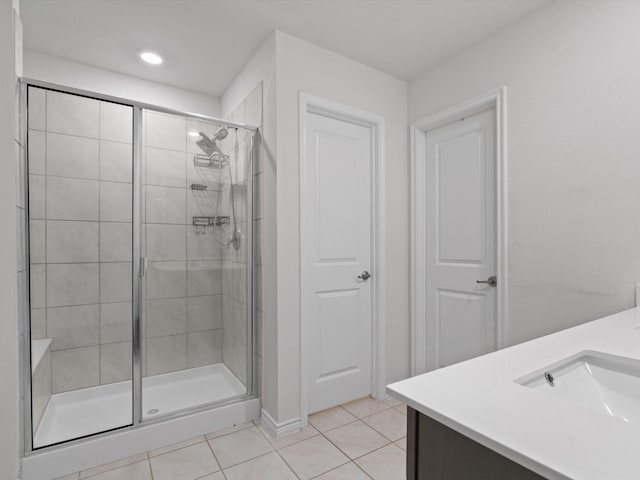 bathroom with tile patterned flooring, a shower stall, and vanity