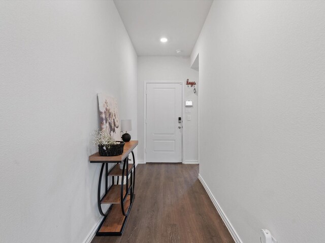 entryway featuring baseboards and dark wood-style floors