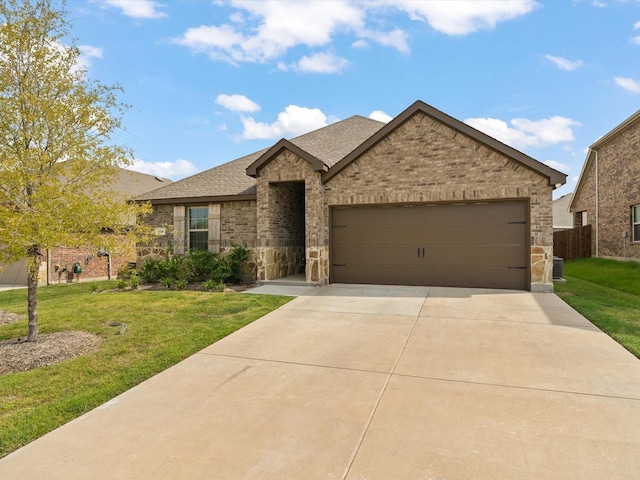 view of front of property with brick siding, a shingled roof, a front lawn, a garage, and driveway