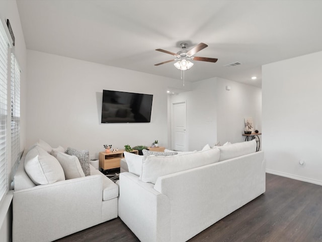 living area with ceiling fan, dark wood-style floors, visible vents, and baseboards