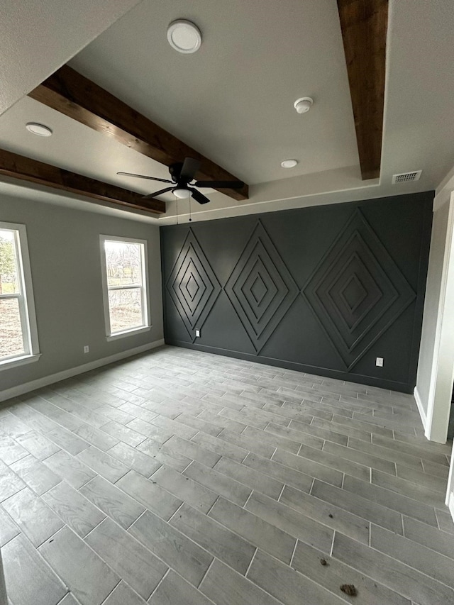 unfurnished room with beamed ceiling, visible vents, baseboards, and ceiling fan