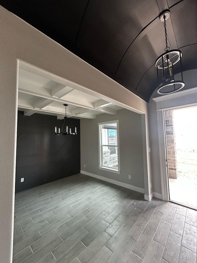 spare room featuring beam ceiling, baseboards, and wood tiled floor