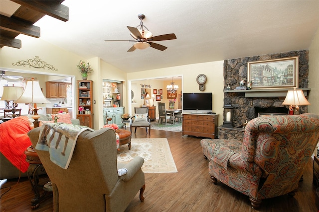 living room featuring wood finished floors, a fireplace, vaulted ceiling, a textured ceiling, and ceiling fan with notable chandelier