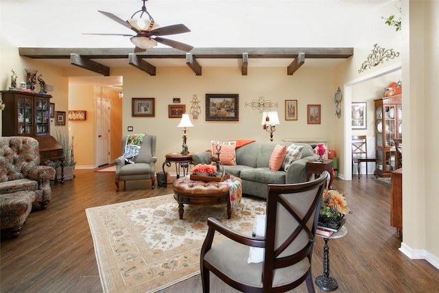 living area featuring dark wood-type flooring, beamed ceiling, baseboards, and ceiling fan