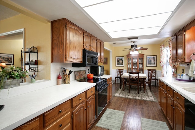 kitchen featuring light countertops, brown cabinets, black appliances, a ceiling fan, and dark wood-style flooring