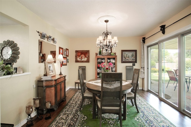 dining area with a notable chandelier, baseboards, and dark wood-style flooring