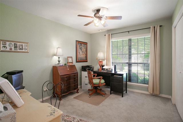 carpeted home office featuring a ceiling fan and baseboards