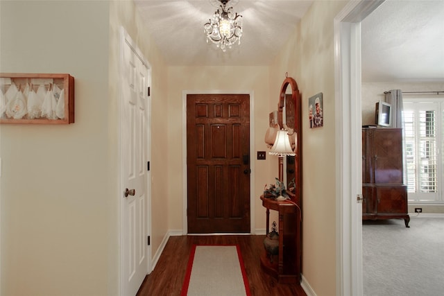 entryway featuring an inviting chandelier, baseboards, and wood finished floors