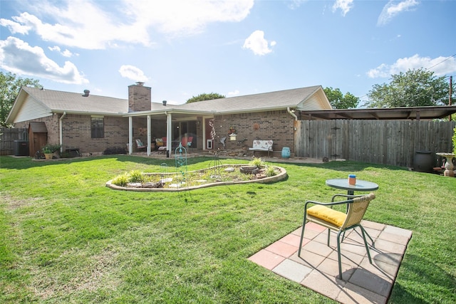 rear view of property featuring brick siding, a patio area, and a yard