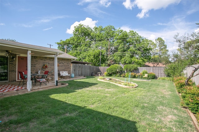 view of yard featuring a ceiling fan, a patio, and a fenced backyard