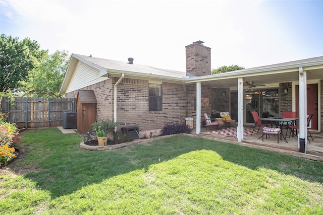 back of property with a patio area, a yard, a chimney, and fence