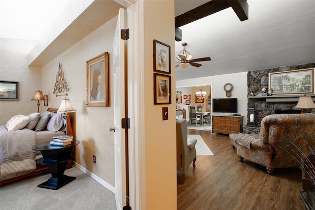 bedroom with a notable chandelier, a fireplace, baseboards, and wood finished floors