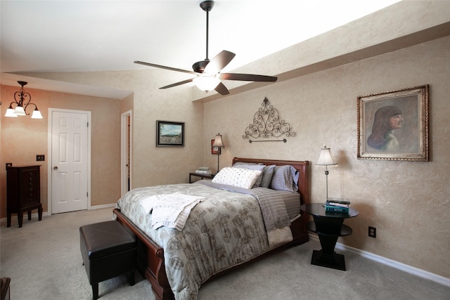 carpeted bedroom with ceiling fan with notable chandelier and baseboards