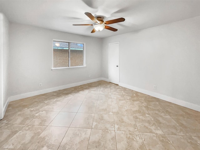 unfurnished room featuring light tile patterned flooring, a ceiling fan, and baseboards