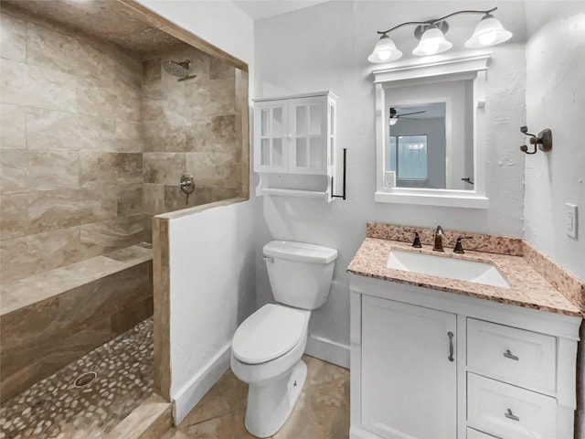 bathroom with toilet, tile patterned flooring, baseboards, walk in shower, and vanity