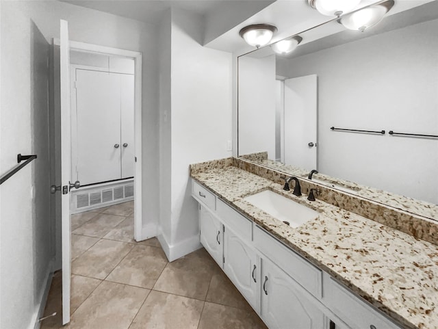 bathroom with tile patterned flooring, vanity, visible vents, and baseboards