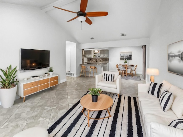 living area featuring light tile patterned flooring, visible vents, beamed ceiling, and ceiling fan