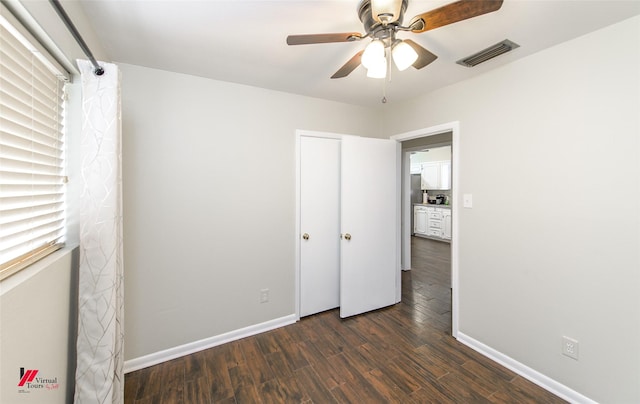 unfurnished bedroom with ceiling fan, wood finished floors, visible vents, and baseboards