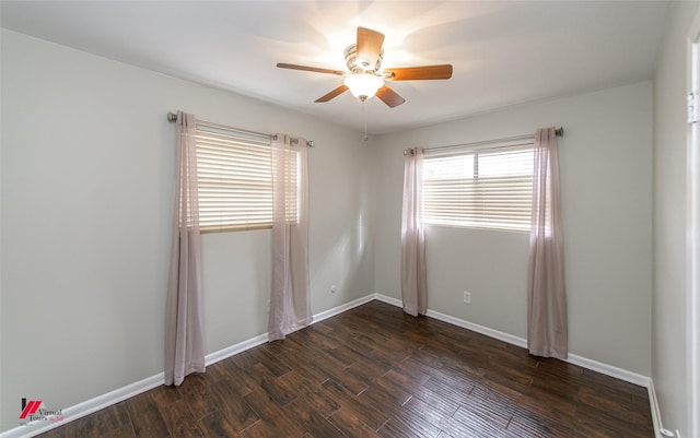 spare room featuring baseboards, ceiling fan, and dark wood-style flooring