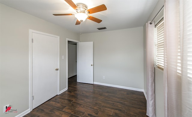 unfurnished bedroom with baseboards, visible vents, dark wood-style flooring, and ceiling fan