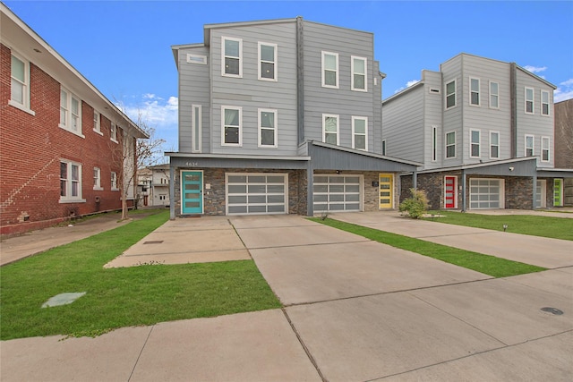 view of front facade featuring a front yard, an attached garage, stone siding, and driveway