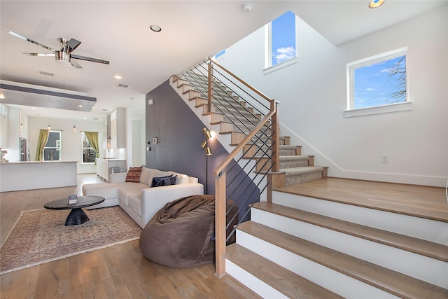 living area featuring stairway, a ceiling fan, wood finished floors, visible vents, and recessed lighting