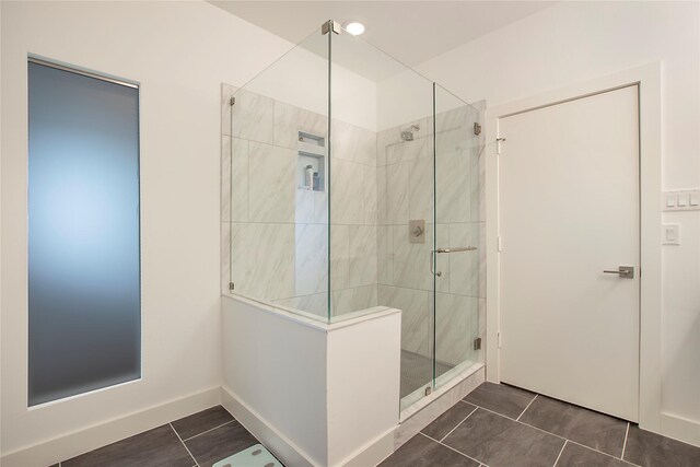 bathroom with tile patterned flooring, a stall shower, and baseboards