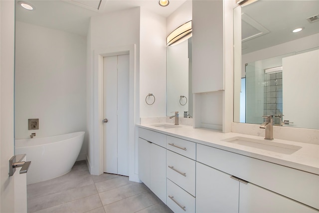 bathroom featuring double vanity, a freestanding tub, a shower stall, and a sink