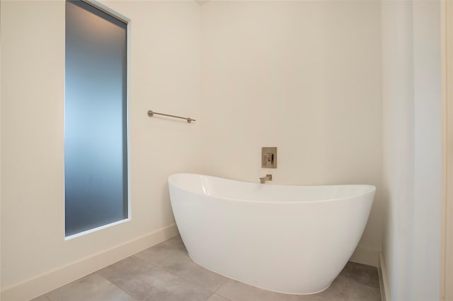 full bathroom with tile patterned floors, baseboards, and a freestanding bath