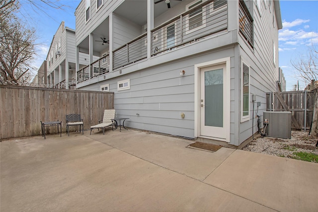 rear view of house with a patio, central AC unit, and a fenced backyard