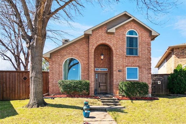 traditional-style home featuring a front lawn and brick siding