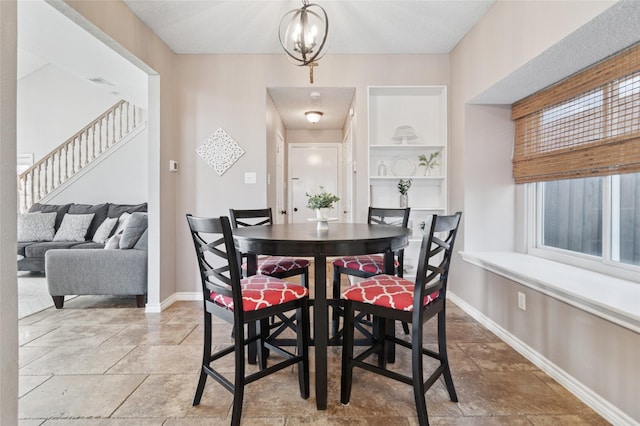 dining space with a chandelier, stairs, and baseboards