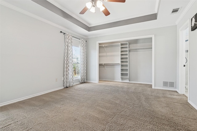 unfurnished bedroom with a raised ceiling, carpet, and visible vents