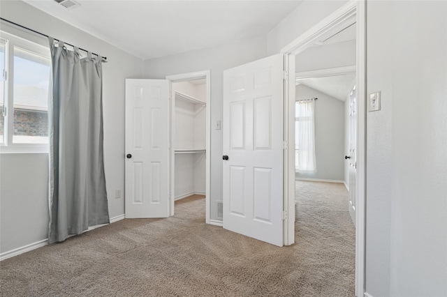 unfurnished bedroom featuring baseboards, carpet floors, and a spacious closet